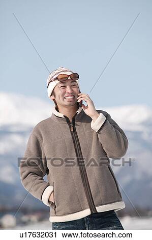 Stock Image - Young man using mobile phone. Fotosearch