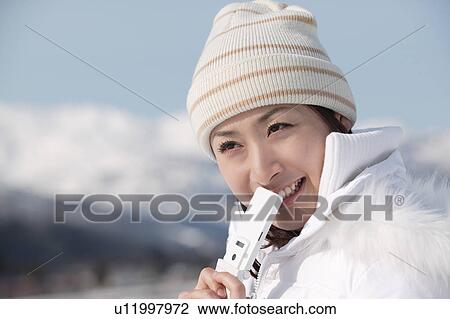 Stock Image - Young woman holding mobile phone. Fotosearch