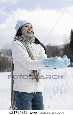 Stock Photograph - Young woman holding snow. Fotosearch