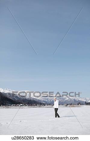 Young woman standing in snow View Large Photo Image Stock Image - Young woman standing in snow. Fotosearch