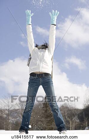 Stock Photo - Young woman throwing snow. Fotosearch
