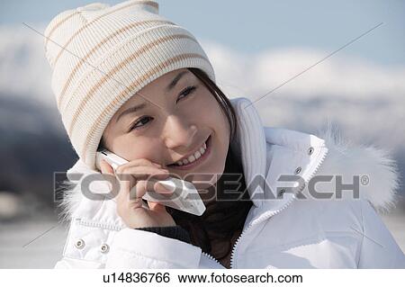 Stock Photograph - Young woman using mobile phone. Fotosearch