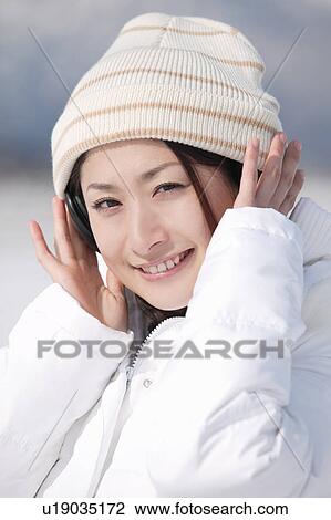 Stock Image - Young woman wearing headphones. Fotosearch