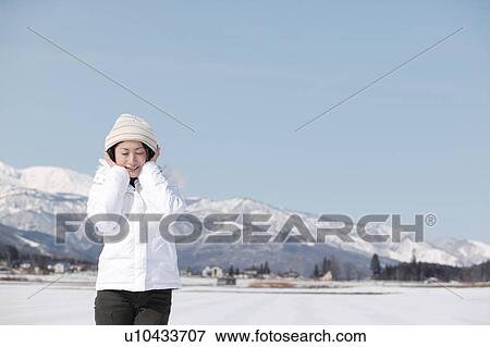 Stock Photo - Young woman wearing headphones. Fotosearch