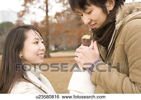 Young couple eating sweet potato View Large Photo Image Stock Photograph - Young couple eating sweet potato. Fotosearch