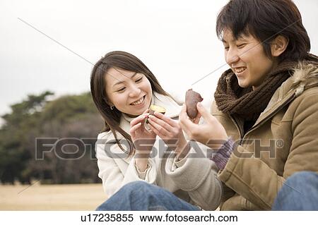Stock Photography - Young couple eating sweet potato. Fotosearch