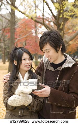 Stock Photo - Young couple sharing cup of coffee. Fotosearch