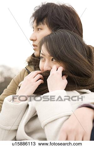 Stock Image - Young couple sharing scarf. Fotosearch