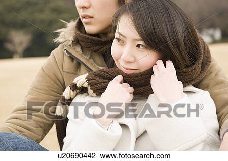 Stock Image - Young couple sharing scarf. Fotosearch
