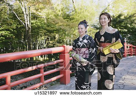 Two young women in kimono crossing bridge View Large Photo Image Stock Photo - Two young women in kimono crossing bridge. Fotosearch