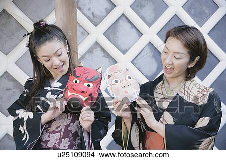 Two young women in kimono holding masks View Large Photo Image Picture - Two young women in kimono holding masks. Fotosearch