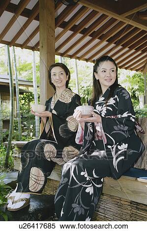 Two young women in kimono holding tea cup View Large Photo Image Stock Photography - Two young women in kimono holding tea cup. Fotosearch