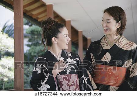 Picture - Two young women in kimono talking. Fotosearch