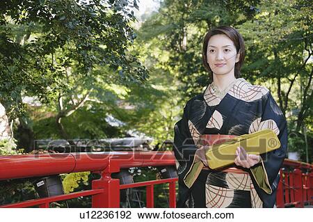 Young woman in kimono crossing bridge View Large Photo Image Stock Image - Young woman in kimono crossing bridge. Fotosearch