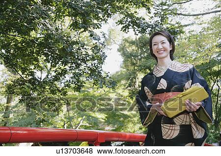 Young woman in kimono crossing bridge View Large Photo Image Stock Photo - Young woman in kimono crossing bridge. Fotosearch
