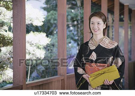 Young woman in kimono holding gift box View Large Photo Image Stock Image - Young woman in kimono holding gift box. Fotosearch