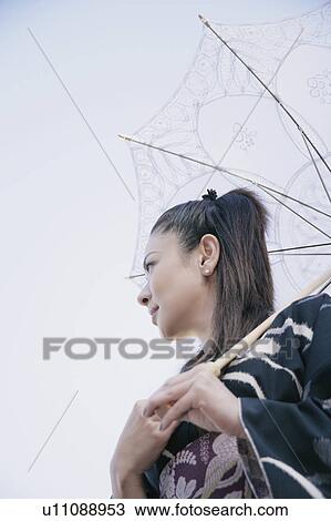 Young woman in kimono holding parasol View Large Photo Image Stock Image - Young woman in kimono holding parasol. Fotosearch