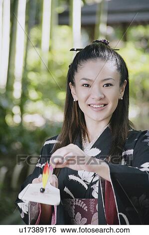 Young woman in kimono holding battledore and shuttlecock View Large Photo Image Stock Photograph - Young woman in kimono holding battledore and shuttlecock. Fotosearch