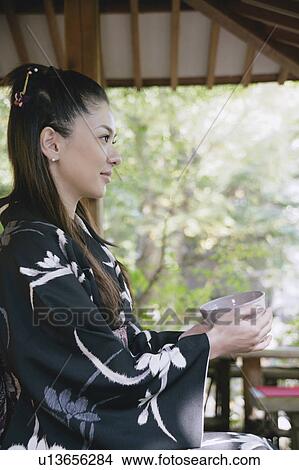 Young woman in kimono holding tea cup View Large Photo Image Picture - Young woman in kimono holding tea cup. Fotosearch