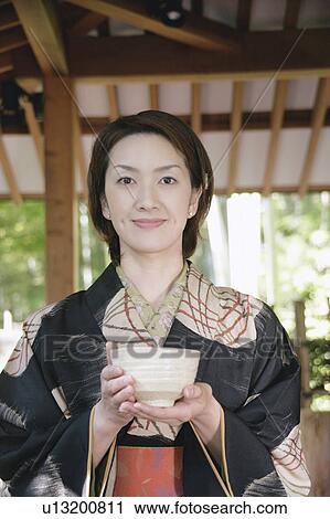 Young woman in kimono holding tea cup View Large Photo Image Stock Image - Young woman in kimono holding tea cup. Fotosearch