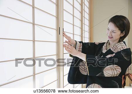 Young woman in kimono opening shoji door View Large Photo Image Stock Photo - Young woman in kimono opening shoji door. Fotosearch