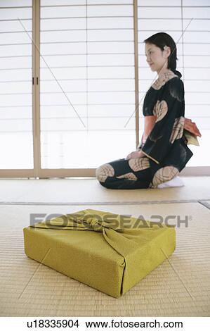 Picture - Young woman in kimono sitting on floor. Fotosearch