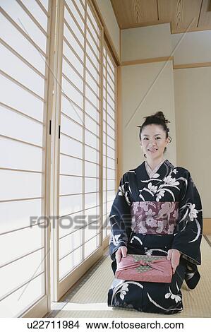 Picture - Young woman in kimono sitting on floor. Fotosearch