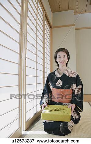 Young woman in kimono sitting on floor View Large Photo Image Stock Photo - Young woman in kimono sitting on floor. Fotosearch