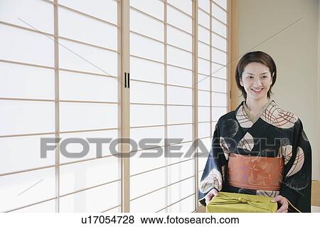 Stock Photo - Young woman in kimono sitting on floor. Fotosearch