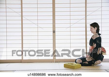 Young woman in kimono sitting on floor View Large Photo Image Stock Photograph - Young woman in kimono sitting on floor. Fotosearch
