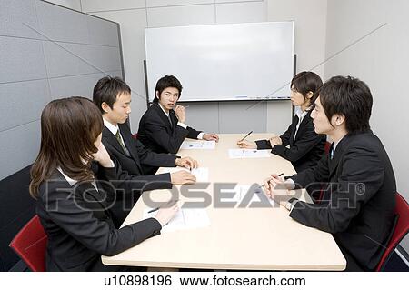 Stock Photograph - Five young people having business meeting. Fotosearch