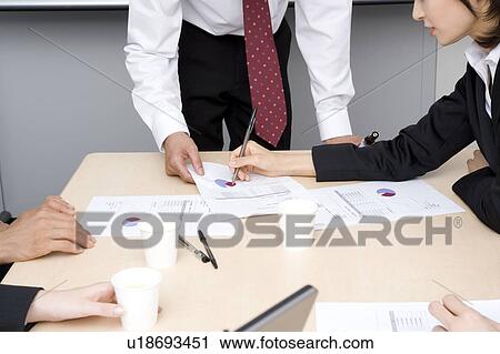 Stock Image - Group of business people having meeting. Fotosearch