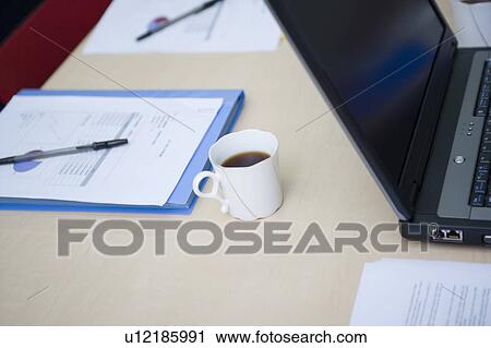Stock Image - Laptop and documents on desk. Fotosearch