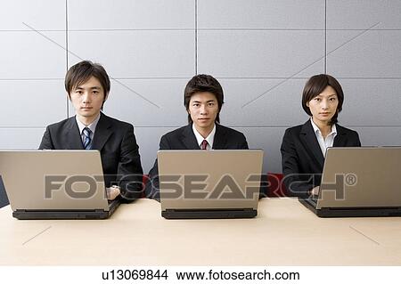 Three young business people using computers View Large Photo Image Picture - Three young business people using computers. Fotosearch