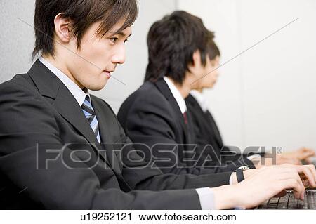 Three young business people using computers View Large Photo Image Stock Image - Three young business people using computers. Fotosearch