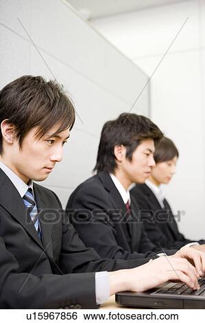 Three young business people using computers View Large Photo Image Stock Photograph - Three young business people using computers. Fotosearch