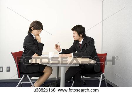 Stock Photo - Two young business people having meeting. Fotosearch