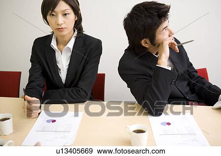 Stock Photo - Young businessman bored during meeting. Fotosearch