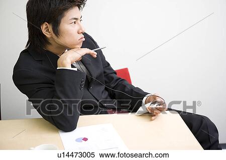 Stock Photography - Young businessman bored during meeting. Fotosearch