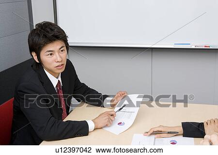 Young businessman in meeting View Large Photo Image Stock Image - Young businessman in meeting. Fotosearch