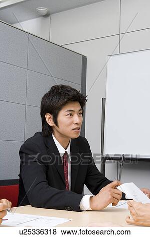 Stock Photo - Young businessman in meeting. Fotosearch
