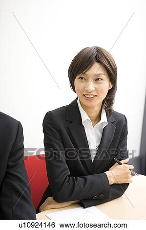 Stock Photograph - Young businesswoman in meeting. Fotosearch