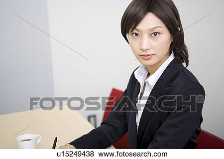 Stock Photo - Young businesswoman looking at camera. Fotosearch