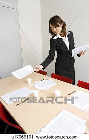 Stock Image - Young businesswoman preparing for meeting. Fotosearch