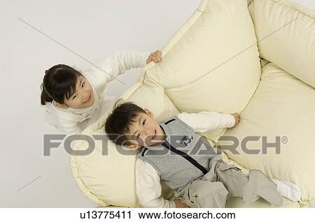 Stock Image - Brother and sister looking at camera. Fotosearch