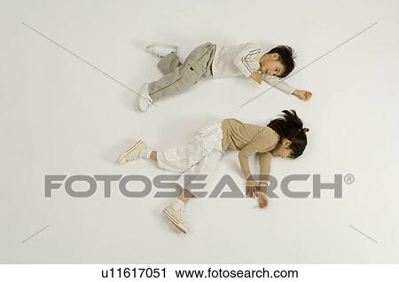 Stock Image - Children lying on floor. Fotosearch