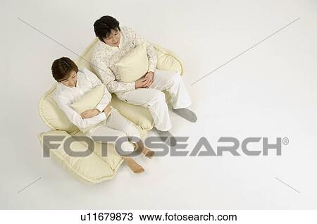 Stock Image - Couple sitting on sofa. Fotosearch