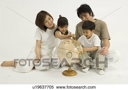 Stock Photography - Family looking at globe. Fotosearch