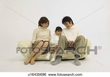 Family sitting on sofa View Large Photo Image Stock Photograph - Family sitting on sofa. Fotosearch