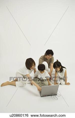 Stock Photograph - Family watching son use computer. Fotosearch